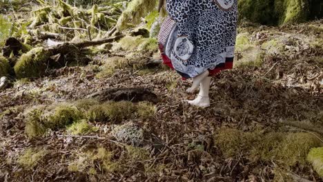 Woman-shaman-walking-barefoot-from-right-to-left-on-moss-covered-rainforest-ground-while-thanking-her-ancestors-for-her-abundance