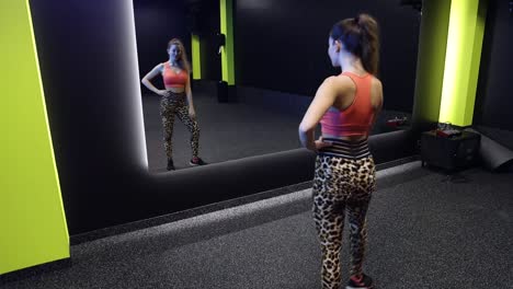 Attraktives-Mädchen,-Das-Vor-Einem-Spiegel-Im-Fitnessstudio-Posiert