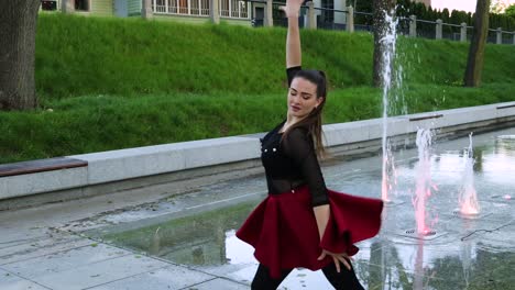 Female-dancer-spins-and-turns-next-to-a-fountain-in-the-park