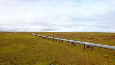 Aerial-view-of-the-Alyeska-pipeline,-oil-transportation-pipe-following-the-Dalton-Highway,-cloudy-day,-in-Alaska,-USA