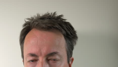 Man-Takes-Temperature-With-Digital-Thermometer-On-Forehead