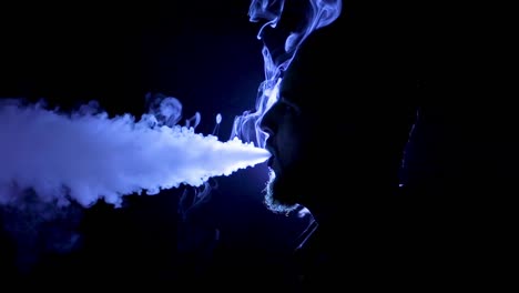 Man-smoking-in-black-studio-with-blue-light
