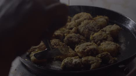 indian-women-hand-flipping-fried-rawa-prawns-in-black-hot-pan-oil