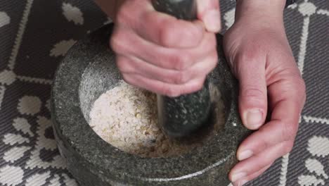 Footage-of-woman-pulverising-Chios-Mastic-and-Mahaleb-in-granite-mortar-medium-shot