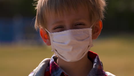 Outdoor-portrait-of-a-little-boy-in-a-protective-face-mask