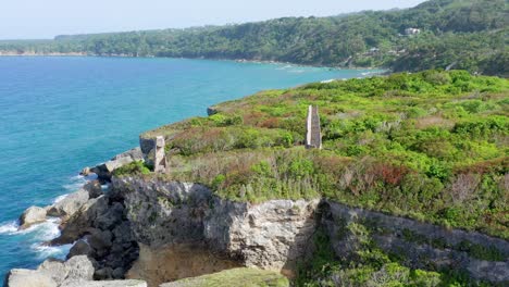 Epic-Drone-Flyover-of-Decrepit-Lighthouse-Ruins-sitting-on-a-Grass-Covered-Cliff-Overlooking-the-Atlantic-Ocean-in-Cabo-Frances,-Dominican-Republic