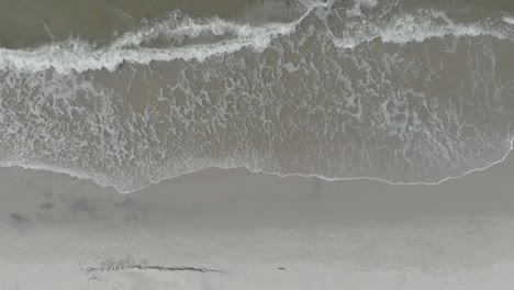 Aerial-top-down-view-of-waves-breaking-on-empty-beach