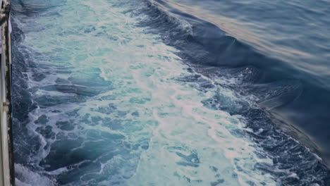 Tilt-shot-of-churning-waters,-made-by-ferry-boat-traveling-at-sea-of-Argosaronikos,-Greece-120fps