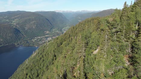 Beautiful-Bandak-Lake-in-Telemark-Norway,-aerial-reveal-behind-mountain-forest