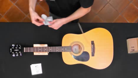 Worker-assembling-guitar-and-placing-guitar-strings-on-guitar-at-workshop