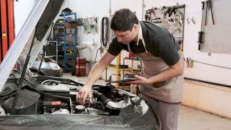 Latin-adult-car-mechanic-does-inspection-service-on-the-car-engine-in-a-repair-shop