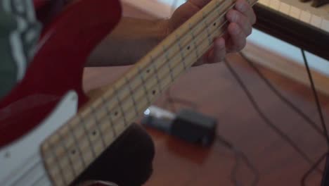Caucasian-musician-plays-the-bass-guitar-at-home-studio
