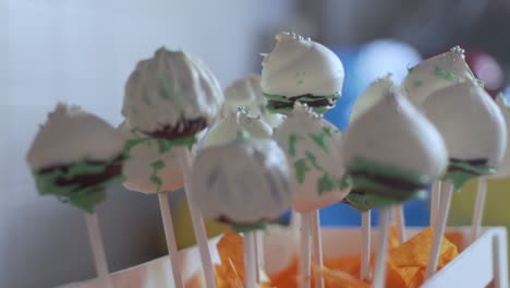 Close-up-of-pile-of-cake-pops-decorated-in-a-wooden-stand-120fps