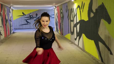Close-up-on-beautiful-female-dancer-practices-dancing-in-graffiti-covered-passage