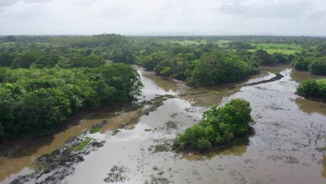 Low-altitude-flight-with-a-view-of-the-floods-caused-by-storm-Laura-in-the-area-of-the-ozama-wetlands,-taken-with-a-drone