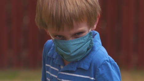 Angry-little-boy-takes-off-his-protective-face-mask