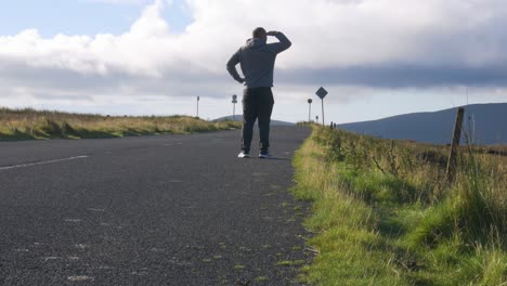 Hombre-Perdido-Caminando-Por-El-Camino-Cuesta-Arriba,-Buscando-Y-Buscando-El-Camino-Correcto-En-Las-Montañas-Wicklow-En-Irlanda