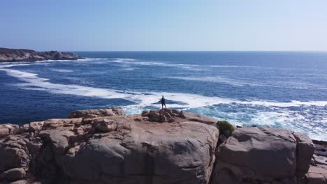 Man-climbing-rock-in-the-sea