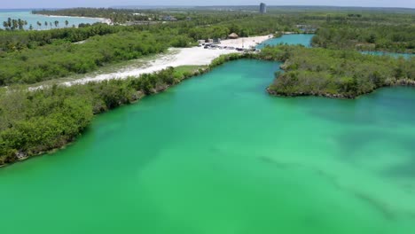 Flight-over-the-blue-lake-in-cap-cana,-Punta-Cana,-vegetation-and-blue-waters-on-a-clear-day