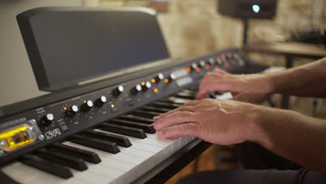 Musician-plays-Synthesizer-at-home-studio,-side-view-4K