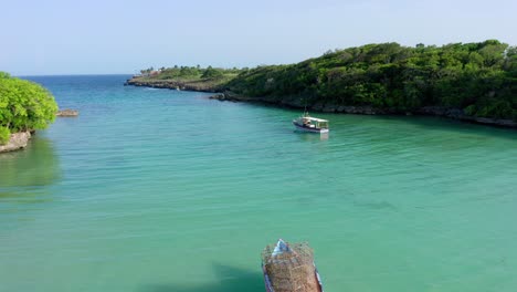 Flight-down-at-Diamanté-beach,-Cabrera,-seeing-two-boats-and-the-turquoise-blue-waters-on-a-clear-day