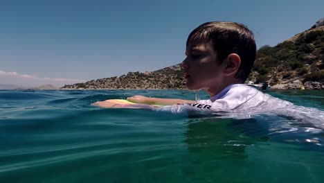 Niño-Caucásico-Nadando-En-El-Mar-De-Sofiko,-Corinto,-Grecia