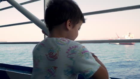 Caucasian-kid-enjoys-the-trip-with-ferry-boat-at-Argosaronikos,-Greece-4?