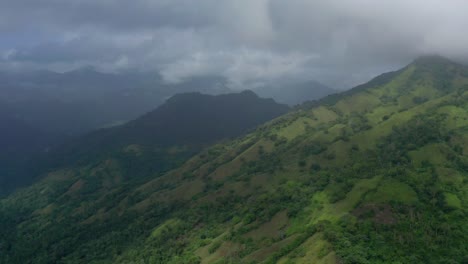 Vuelo-A-Gran-Altura-En-Las-Altas-Montañas-Verdes-De-La-República-Dominicana-Con-Vistas-A-Las-Nubes-Grises