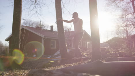LENS-FLARE-SLO-MO---A-man-in-his-60s-balancing-on-a-slack-line-before-coming-off