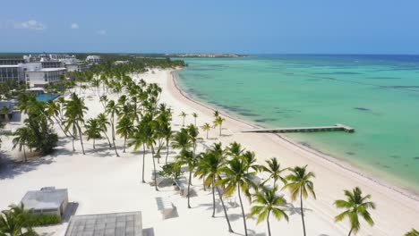 Scenic-flight-at-low-altitude-on-the-beach-of-Juanillo,-seeing-the-white-sand,-turquoise-blue-water-and-the-green-palms