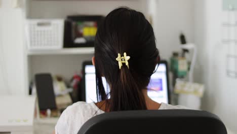 Woman-using-computer-viewed-from-behind.-Close-up