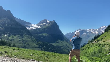 person-looking-and-photographing-mountains-in-glacier-national-park
