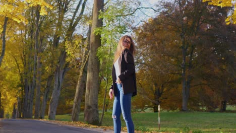 Teenager-Mädchen-An-Einem-Sonnigen-Herbsttag-Posiert-In-Einem-öffentlichen-Park-Mit-Bunten-Blättern