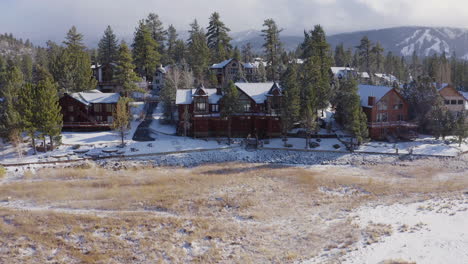 Coming-home-to-Big-Bear-California-mansion-outskirts-aerial-Snow-covered-Mountains-drone