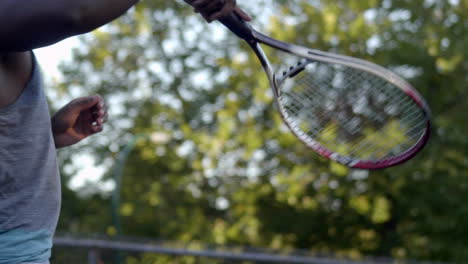Black-Man-Tossing-Tennis-Ball-With-A-Racket---close-up-slowmo