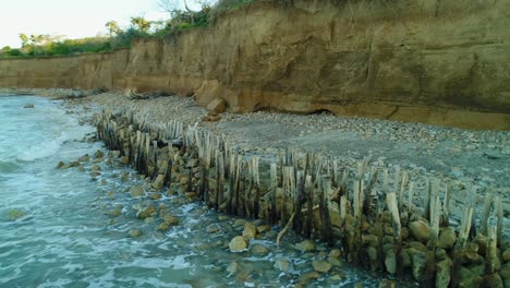 Popa-beach-stone-and-wooden-barrier-against-sea-erosion,-Dominican-Republic