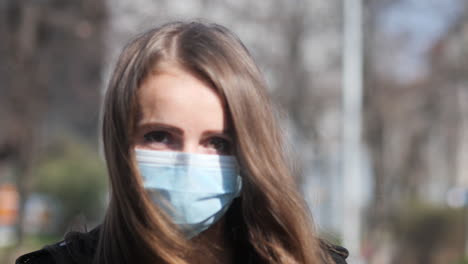 Sad-Eyes-Behind-Face-Mask-of-Young-Woman-Walking-in-City-Outdoor-During-Covid-19-Virus-Pandemic-Looking-At-Camera,-Slow-Motion
