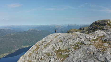 Girl-standing-in-breathtaking-Norwegian-fjord-landscapes