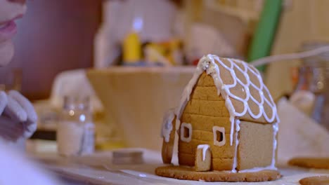 Close-up-on-caucasian-woman,-staring-and-preparing-a-gingerbread-cookies-house-4k