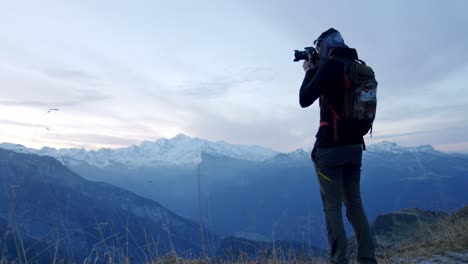 Hiker-is-taking-a-photograph-from-the-top-of-a-mountain-with-Mt-Blanc-in-the-background