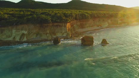 Sun-rays-illuminate-Popa-beach-rocky-cliffs,-Dominican-Republic