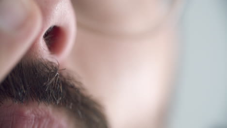 Extreme-close-up-shot-of-a-man-clipping-his-nose-hair-with-sharp-scissors