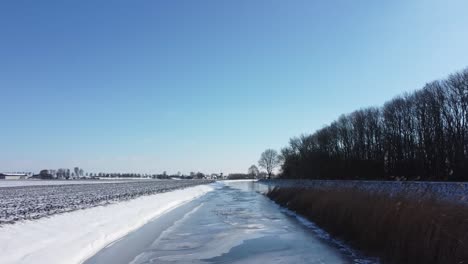Drone-flies-over-a-ditch-in-a-Dutch-winter-landscape