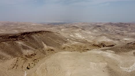 Aerial-forward-slow-and-calm-drone-shot-of-an-empty-hills-in-the-Arad,Israeli-desert,-blue-sky-on-a-sunny-day