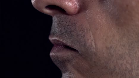 Extreme-close-up-shot-of-a-male-addict-holding-a-tourniquet-in-his-mouth-to-tighten-it-around-his-arm
