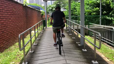 Chinese-man-cycling-on-covered-pathway