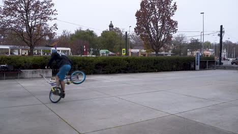 Chico-Montando-Una-Bicicleta-Bmx-En-Un-Skatepark,-Haciendo-Trucos-De-Giro-Y-Equilibrio