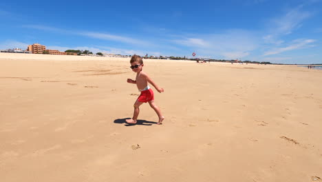 Niño-Pequeño-Caucásico-De-Vacaciones-Corriendo-Alegremente-En-La-Playa-Soleada