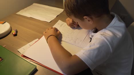 Footage-of-caucasian-six-years-old-boy,-doing-his-homework-lessons-at-home-4K,-side-view,-medium-shot