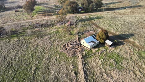 Drone-footage-from-a-bright-sunny-day-over-Clarksville,-California,-USA,-moving-over-farmstead-buildings-and-green-smallholdings-and-towards-a-busy-highway-with-streaming-traffic